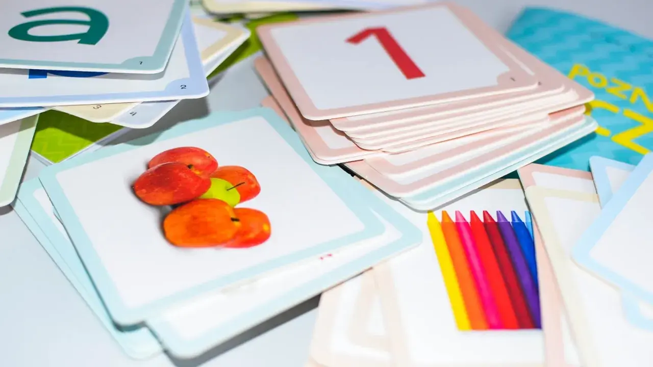 Kolorowe karty edukacyjne z literą "a", jabłkami, cyfrą "1" i kredkami. Zestaw do nauki, który pomaga dziecku, gdy kończy alfabet.