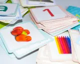 Kolorowe karty edukacyjne z literą "a", jabłkami, cyfrą "1" i kredkami. Zestaw do nauki, który pomaga dziecku, gdy kończy alfabet.