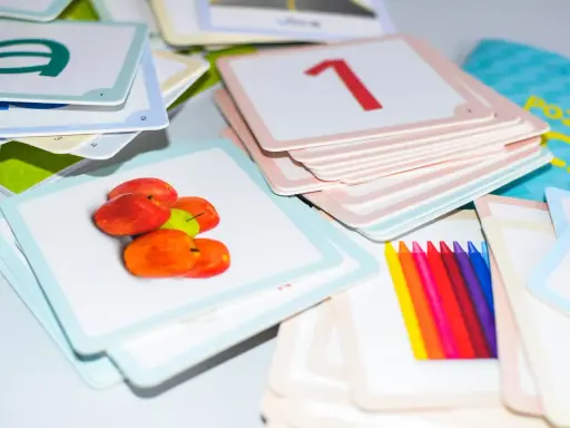 Kolorowe karty edukacyjne z literą "a", jabłkami, cyfrą "1" i kredkami. Zestaw do nauki, który pomaga dziecku, gdy kończy alfabet.